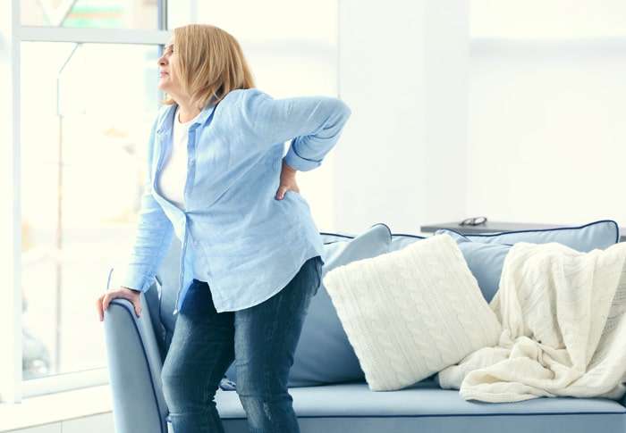 An unhappy woman suffering from back pain